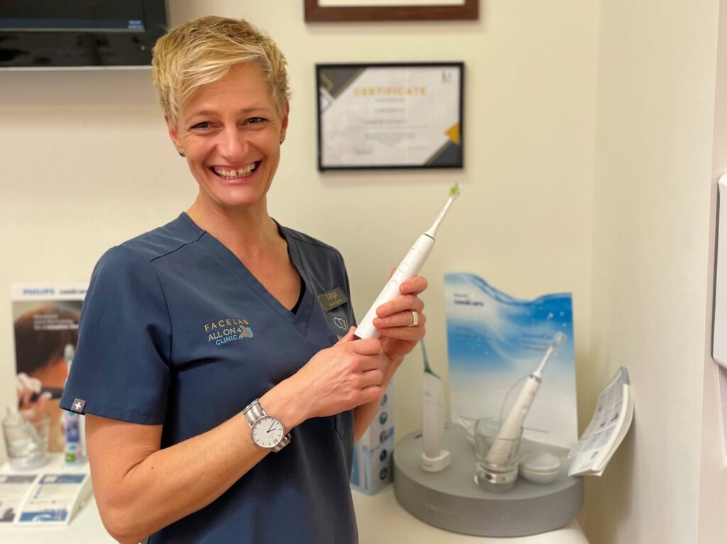 Dental hygienist holding a toothbrush in an active maintenance appointment.